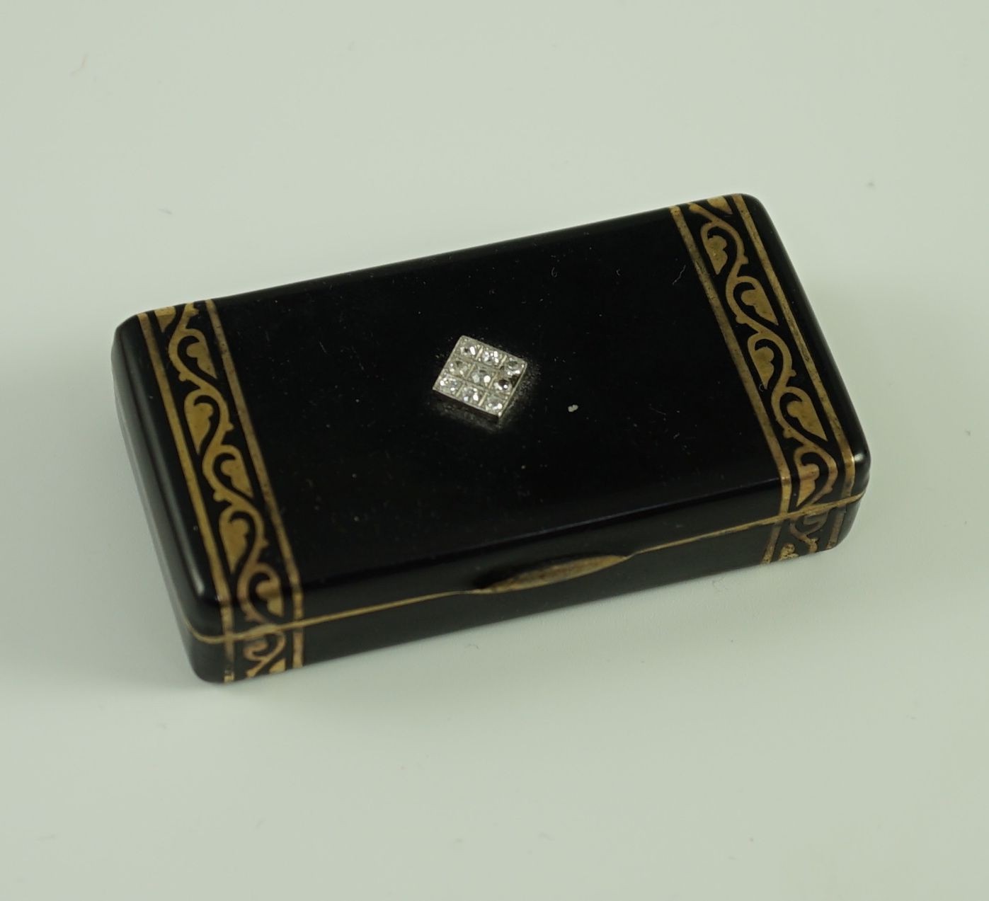 A late 1920's French Cartier silver gilt, black enamel and diamond set snuff box, in fitted gilt tooled leather Cartier box